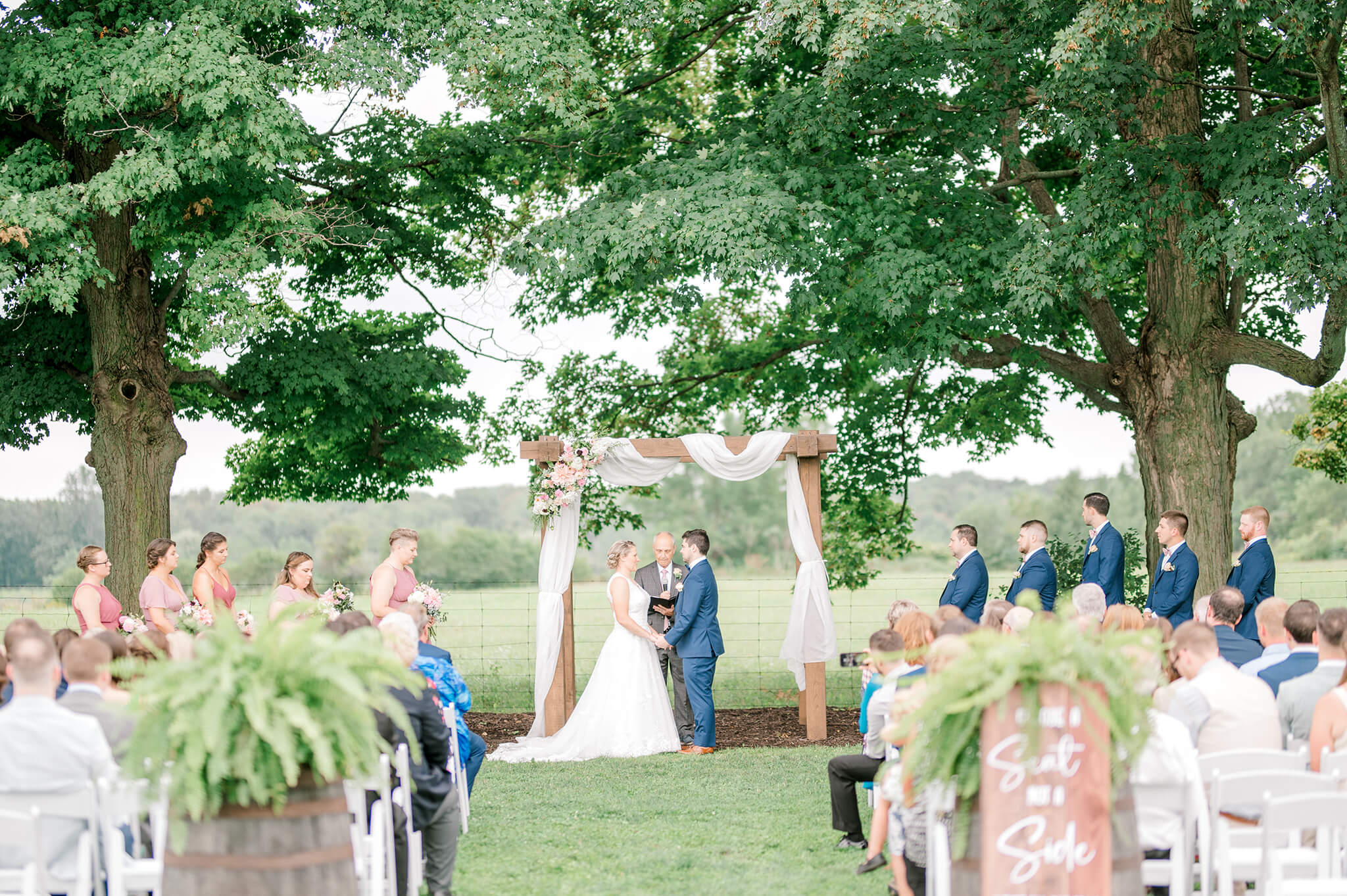 Couple getting married in the orchards at their Maple Meadows Farm Wedding